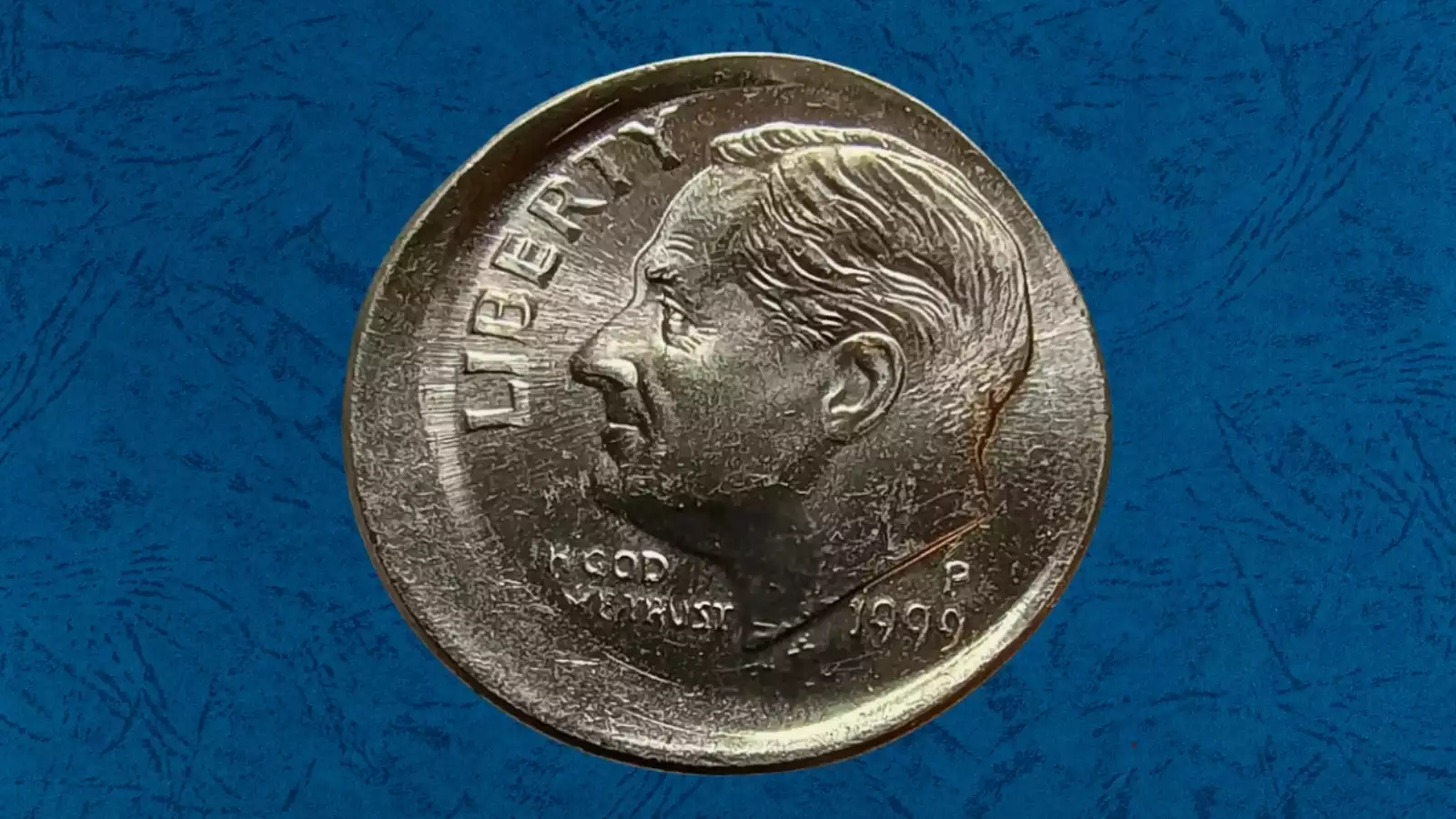 1999 Roosevelt dime broadstrike error showing expanded diameter and missing reeded rim compared to normal dime